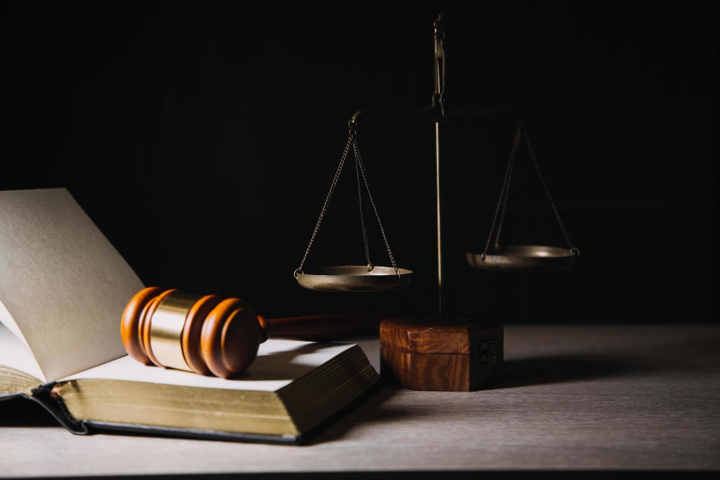 concept de justice et de droit. juge masculin dans une salle d'audience avec le marteau, travaillant avec, clavier d'ordinateur et d'accueil, lunettes, sur table à la lumière du matin photo