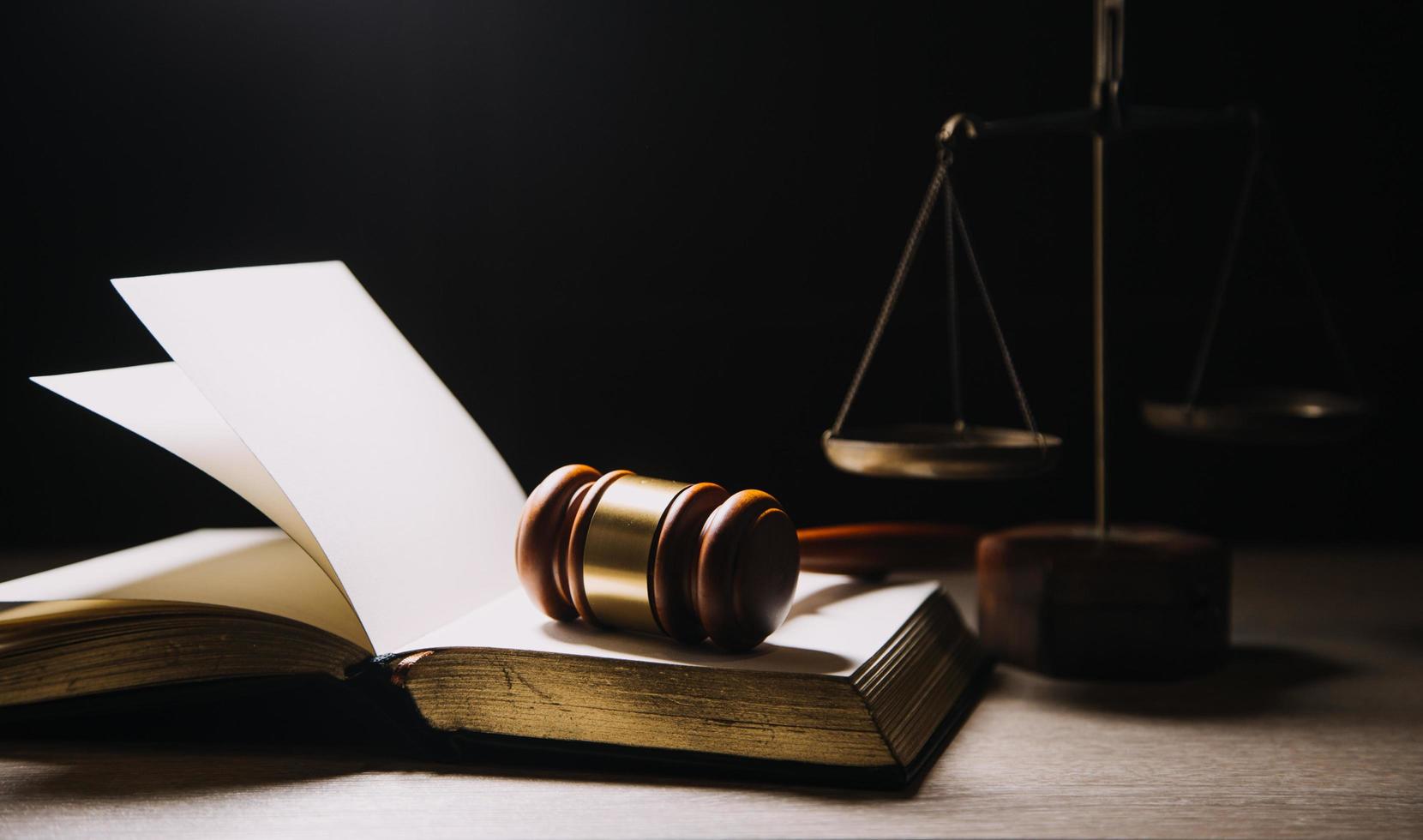 concept de justice et de droit. juge masculin dans une salle d'audience avec le marteau, travaillant avec, clavier d'ordinateur et d'accueil, lunettes, sur table à la lumière du matin photo