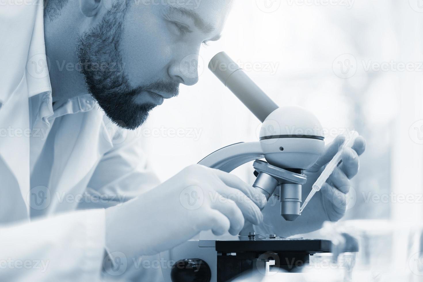 un scientifique utilise un microscope dans un laboratoire pendant des travaux de recherche scientifique photo