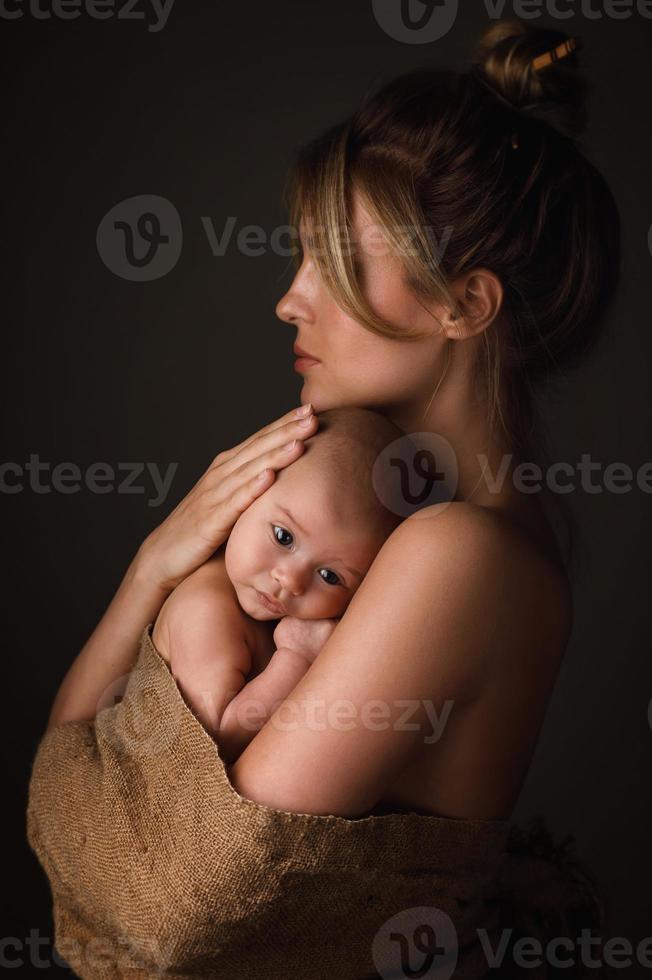 belle mère et son petit bébé sont enveloppés dans un sac photo