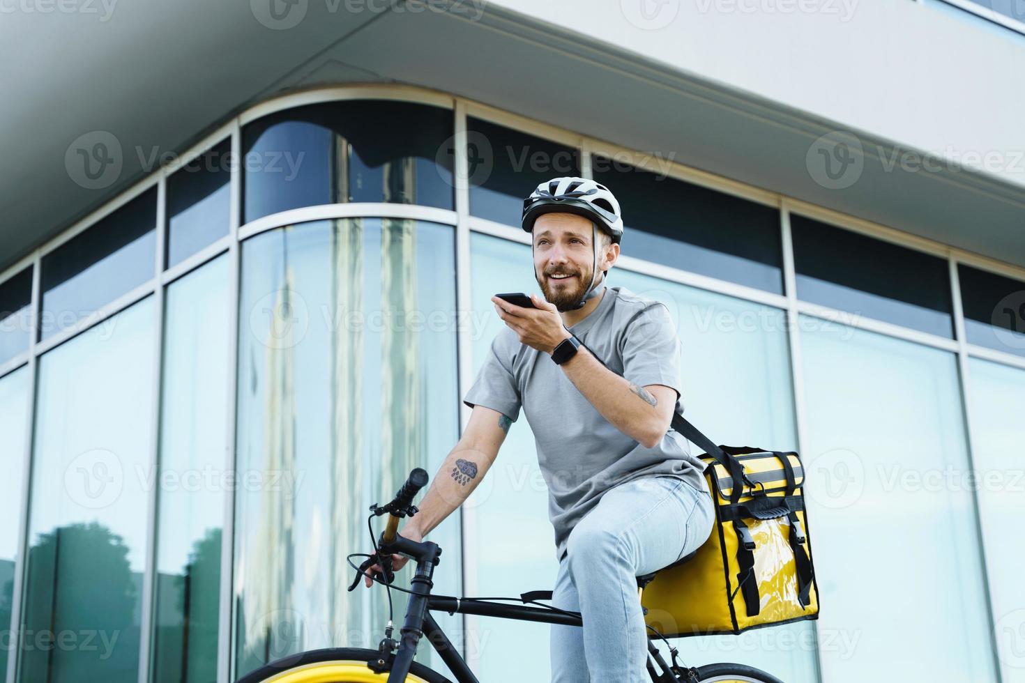 courrier de livraison express avec sac isotherme tenant le téléphone à vélo. photo