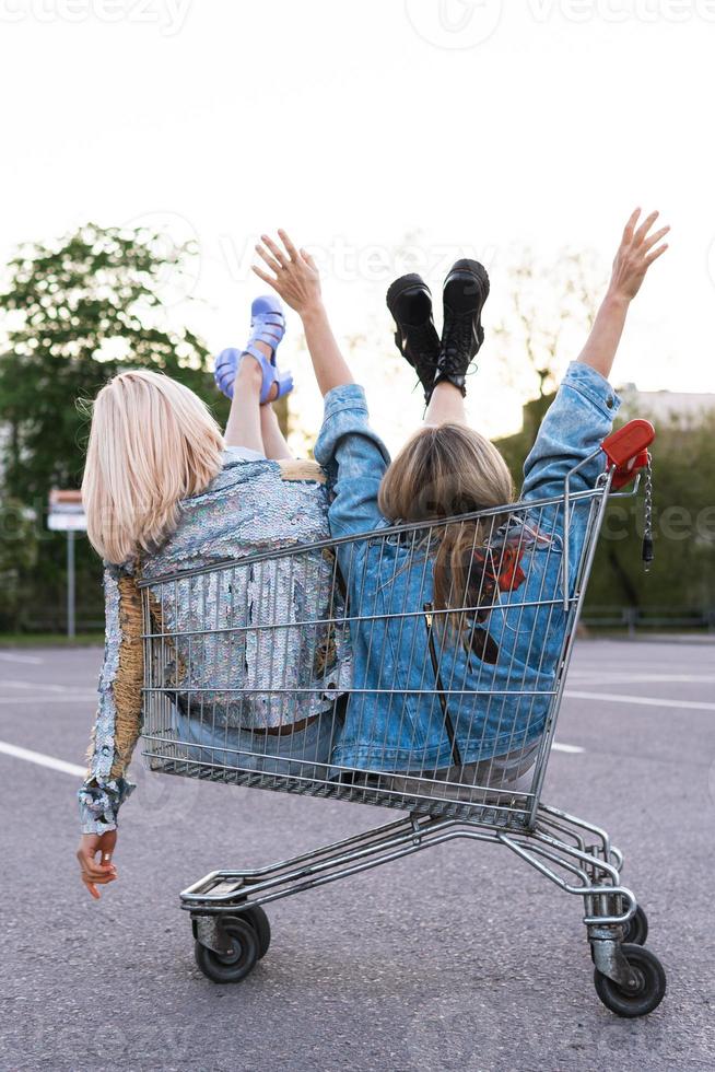 deux jeunes filles heureuses assises dans un caddie photo