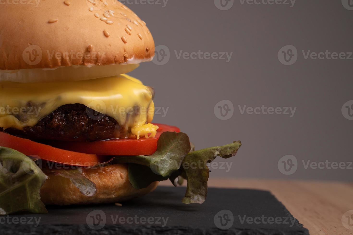 hamburger fait maison frais et savoureux avec légumes frais, laitue, tomate, fromage sur une planche à découper. espace libre pour le texte photo