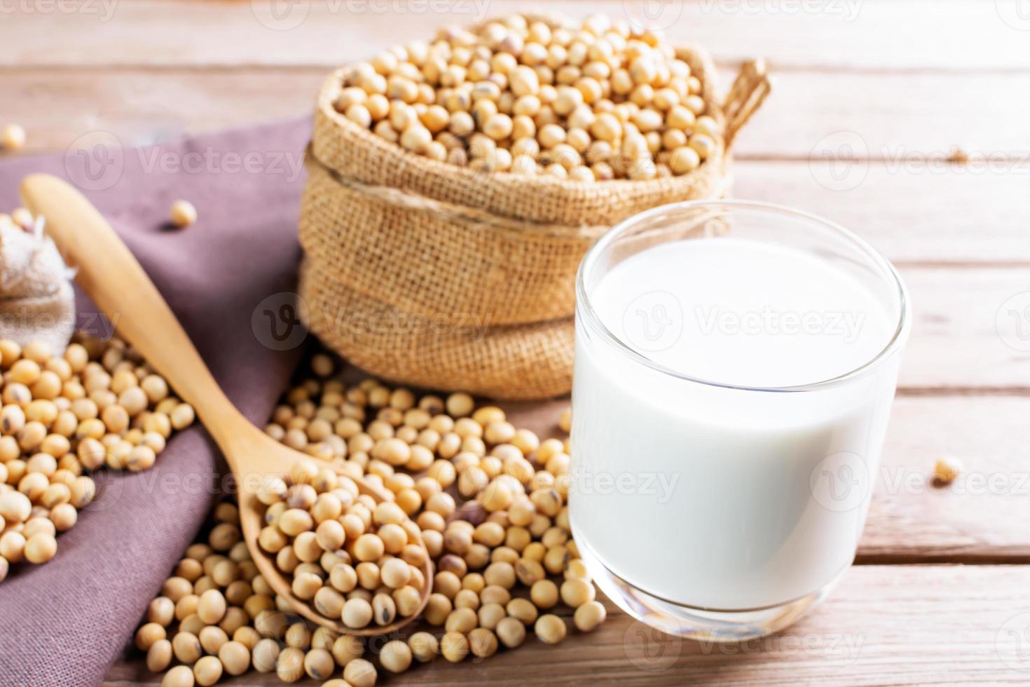 lait de soja dans un verre avec du soja sur une table en bois petit-déjeuner bio, riche en protéines, sain, produits agricoles, végétarien photo