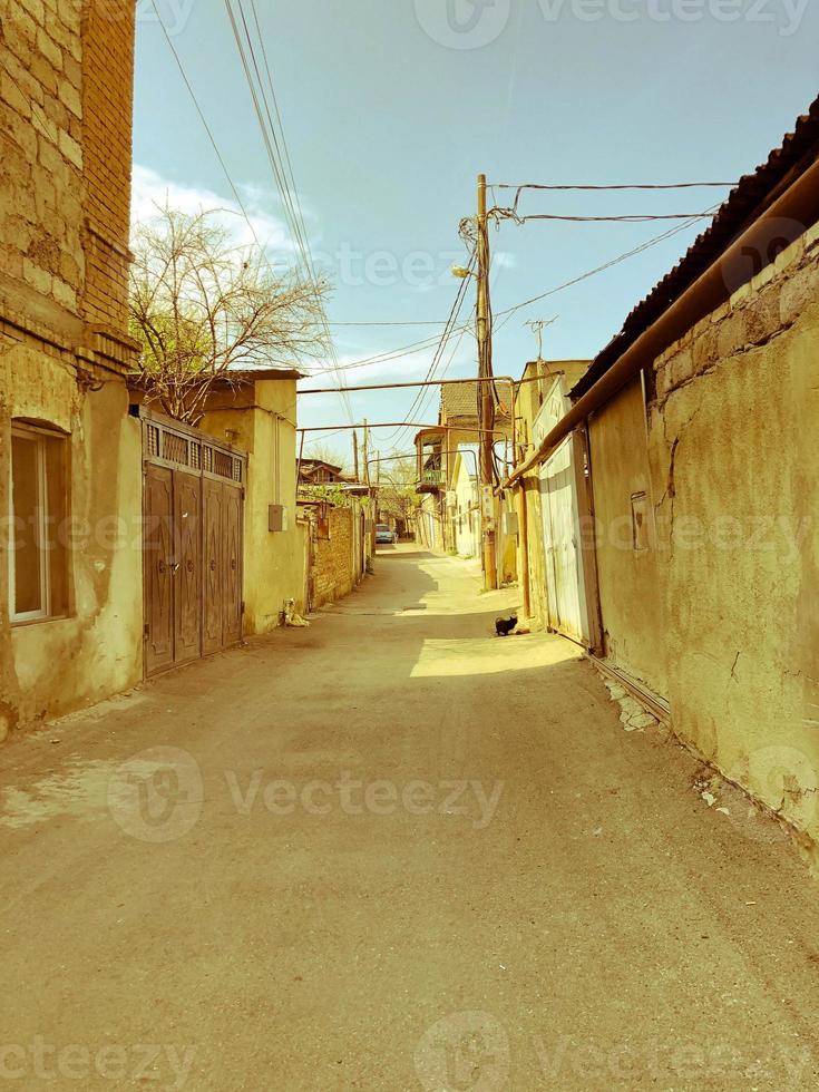 rue étroite, ruelle, tunnel avec de vieilles maisons, immeubles sur les côtés dans un quartier pauvre de la ville, bidonvilles. photographie verticale photo