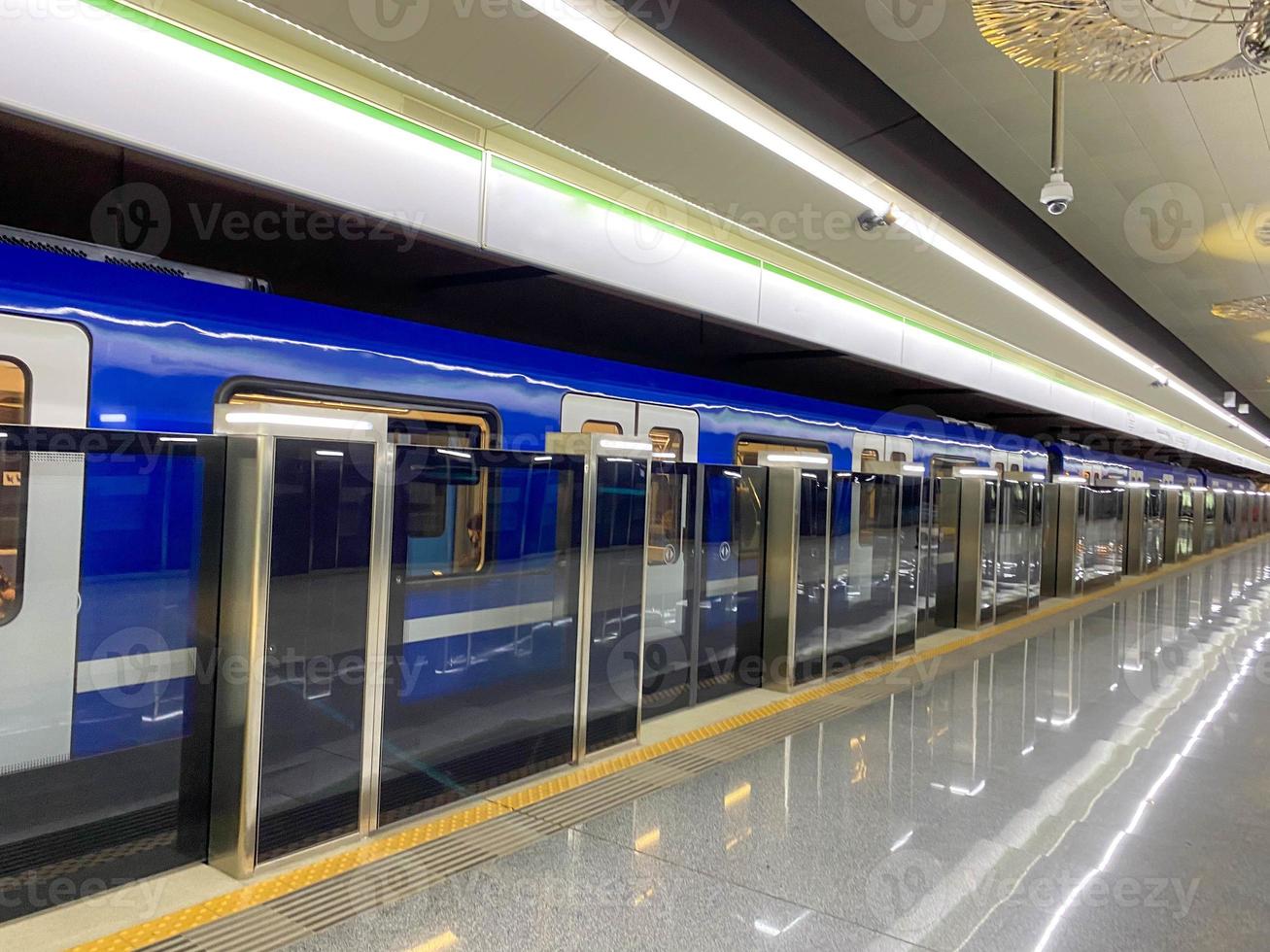 nouvelle rame de métro moderne bleue à grande vitesse rapide et sûre dans la grande ville sur la plate-forme d'attente à la station de métro de la gare photo