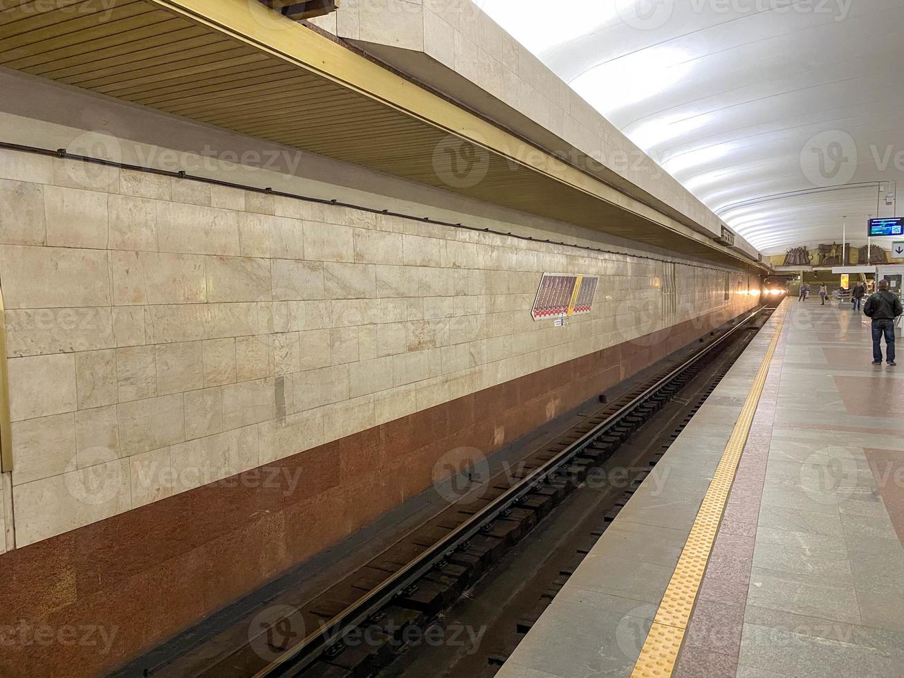 vue du tunnel sur la plate-forme pour les trains en attente à la station de métro avec des murs de granit photo