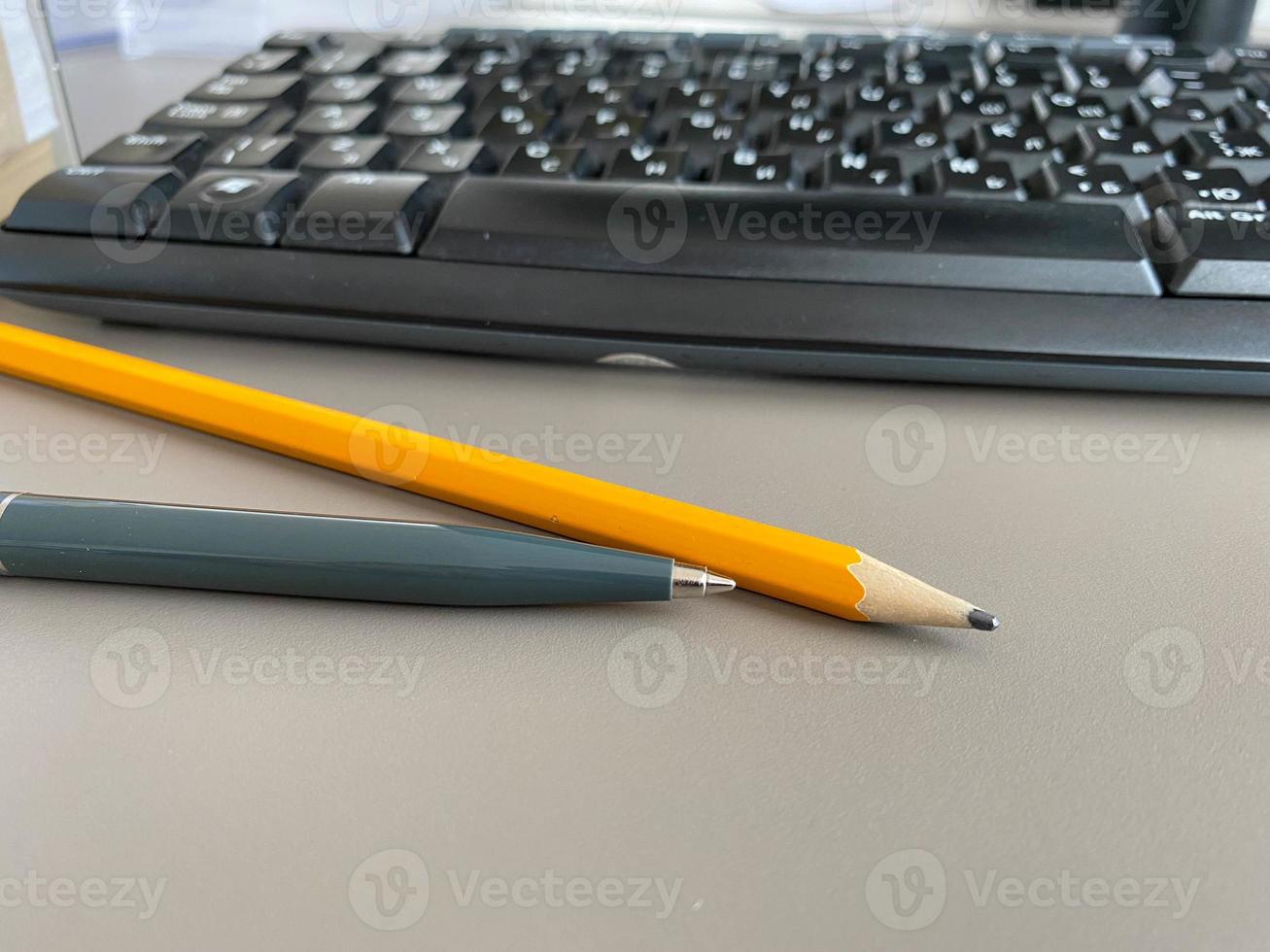 stylo à bille vert automatique et crayon d'écriture sur le bureau de bureau avec clavier d'ordinateur. travail d'entreprise photo