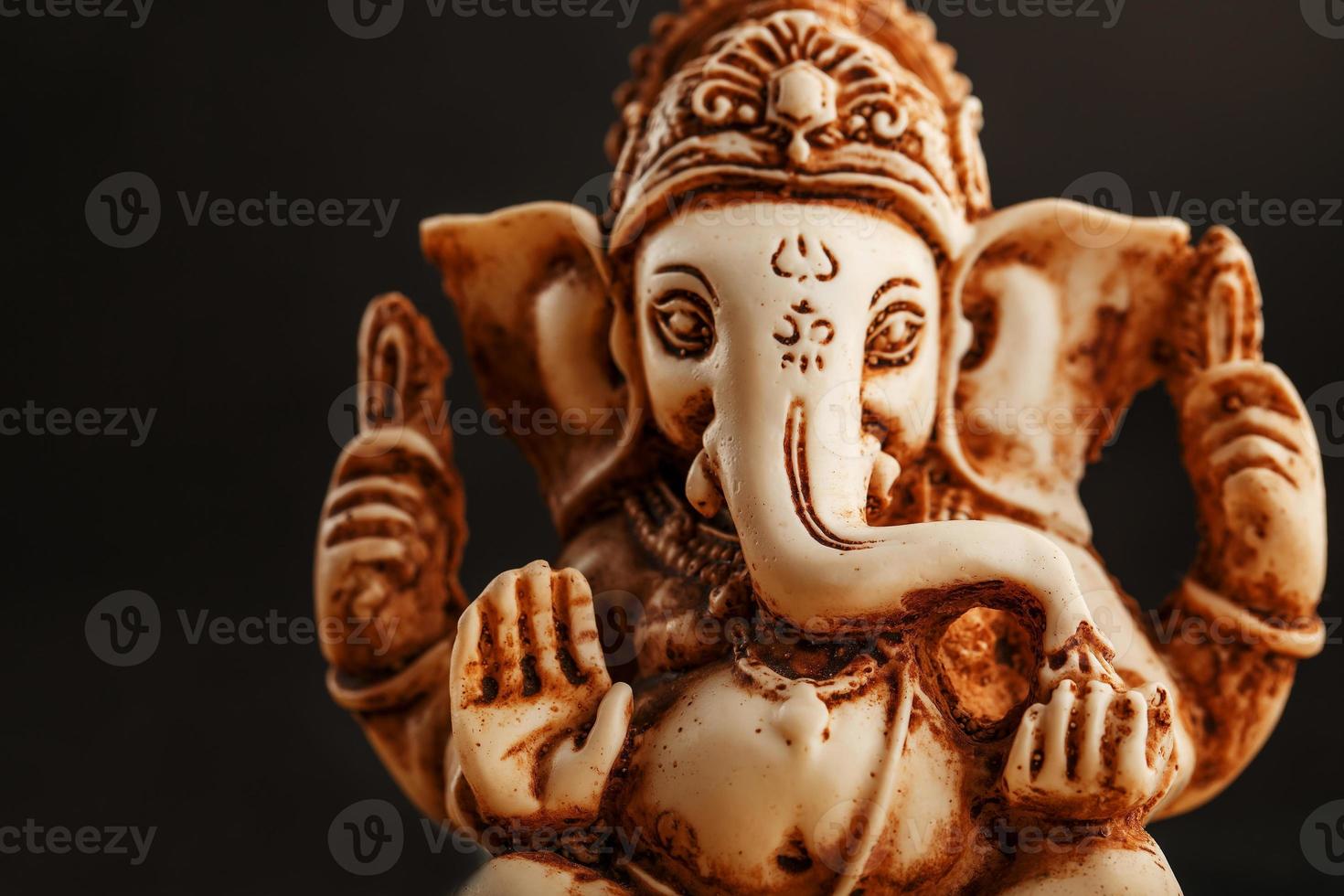 dieu hindou ganesh sur fond noir. statue avec des bâtons d'arôme de fumée d'encens photo