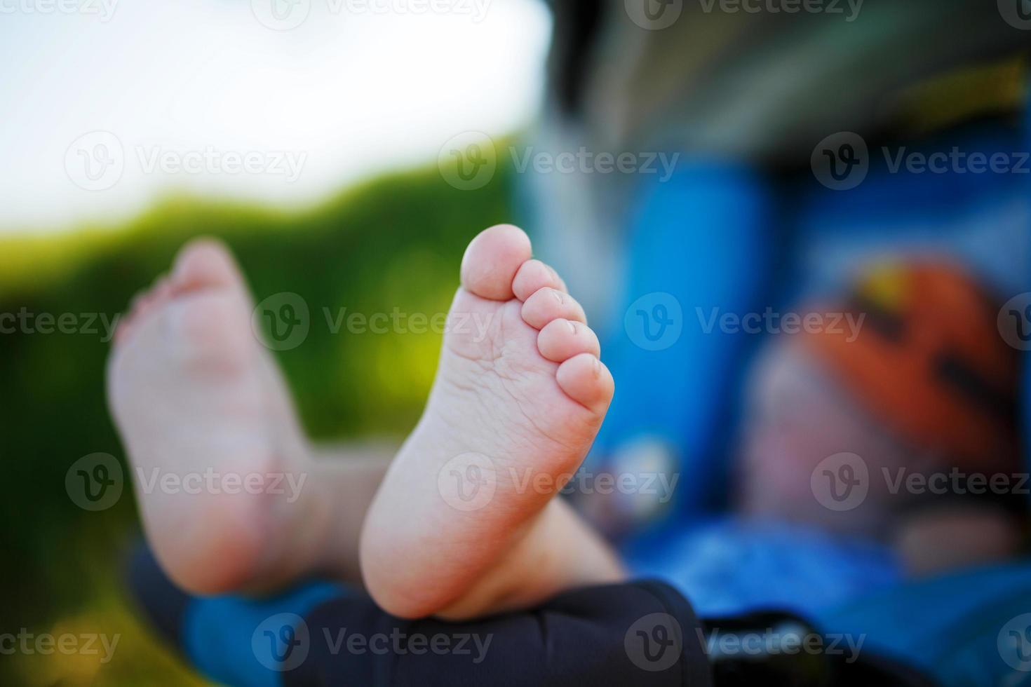 mignon, drôle talons doux d'un enfant dans le contexte d'un couché dans une poussette photo