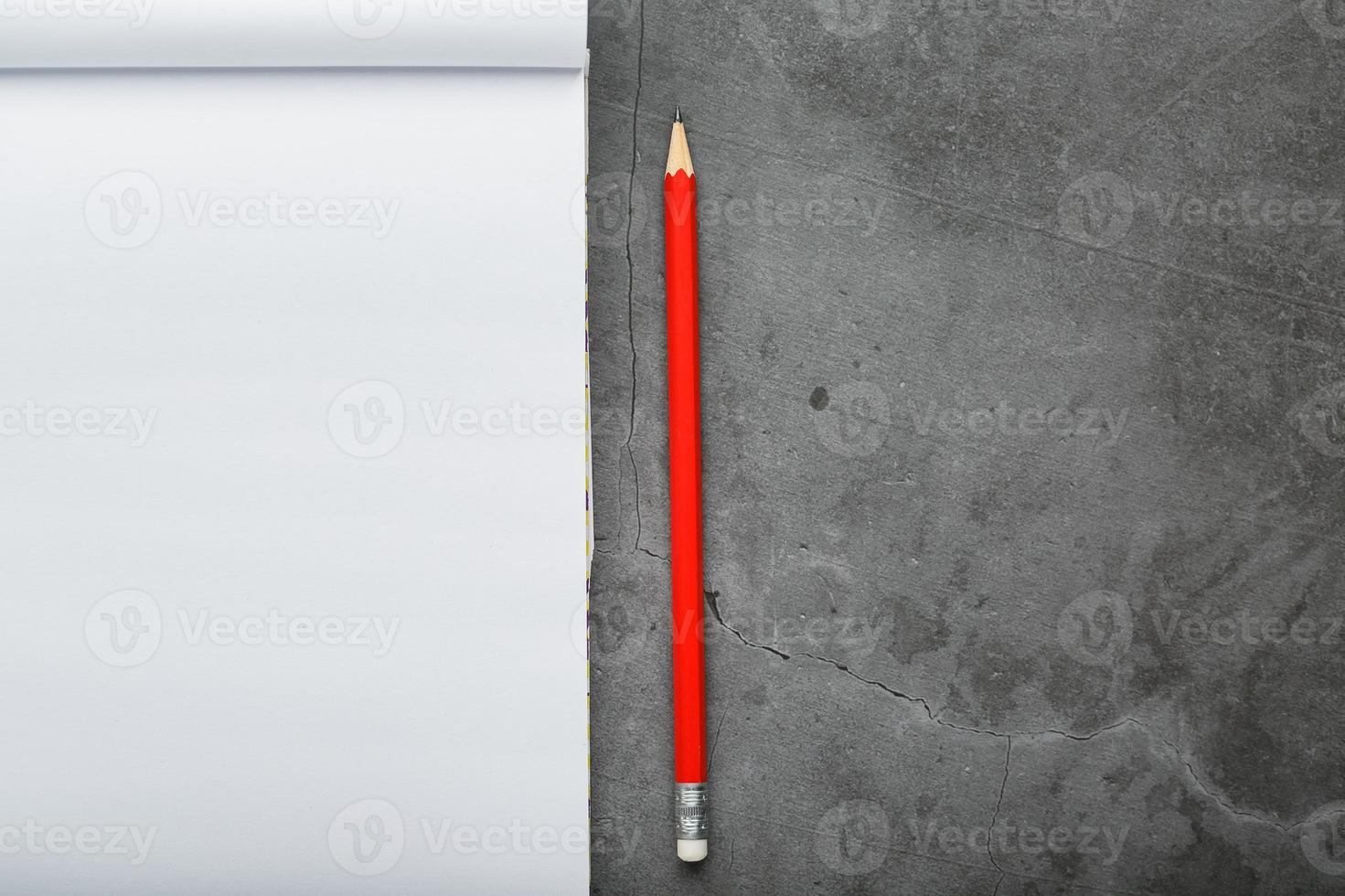 bloc-notes avec un crayon rouge sur fond de plaque de pierre noire, pour l'éducation, l'enregistrement des objectifs et des actes photo