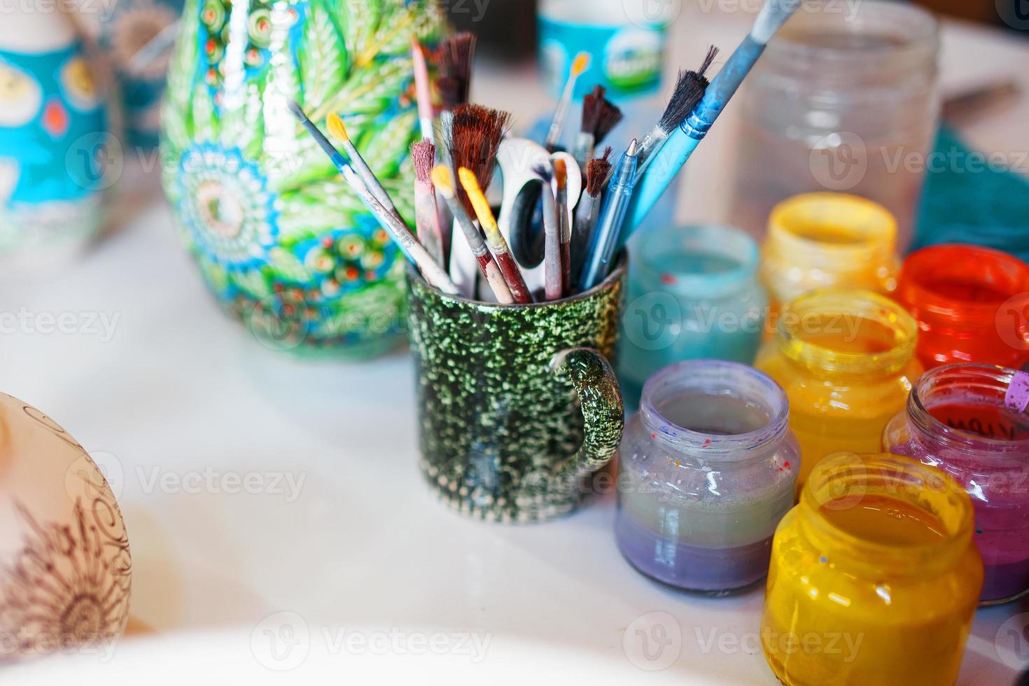 peintures multicolores pour peindre des assiettes en porcelaine par les mains d'un artisan professionnel. photo