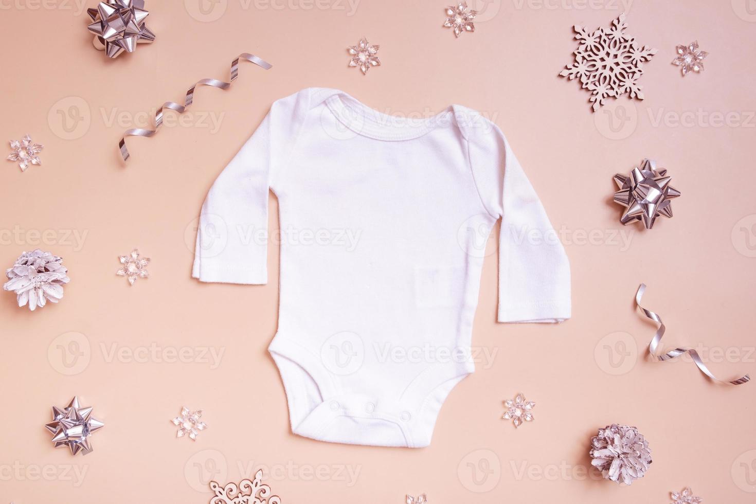 maquette de vêtements pour bébés pour logo, texte ou dessin sur fond rose avec vue de dessus de décorations d'hiver. photo