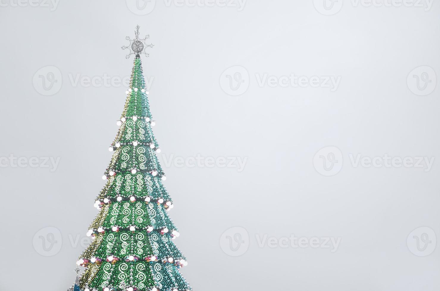 un fragment d'un immense sapin de noël avec de nombreux ornements, coffrets cadeaux et lampes lumineuses. photo d'un sapin de noël décoré en gros plan avec espace de copie