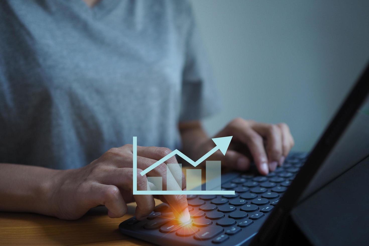 femme d'affaires en appuyant sur le clavier et le graphique. développement et progrès de l'entreprise. notion de croissance économique. photo