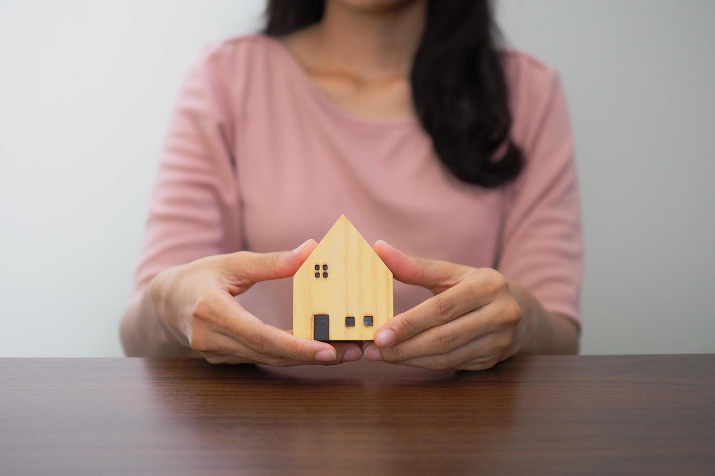 des maisons modèles avec des agents immobiliers discutent d'un contrat d'achat d'une maison, d'un bail, d'une assurance ou d'un prêt immobilier. notion d'entreprise. photo