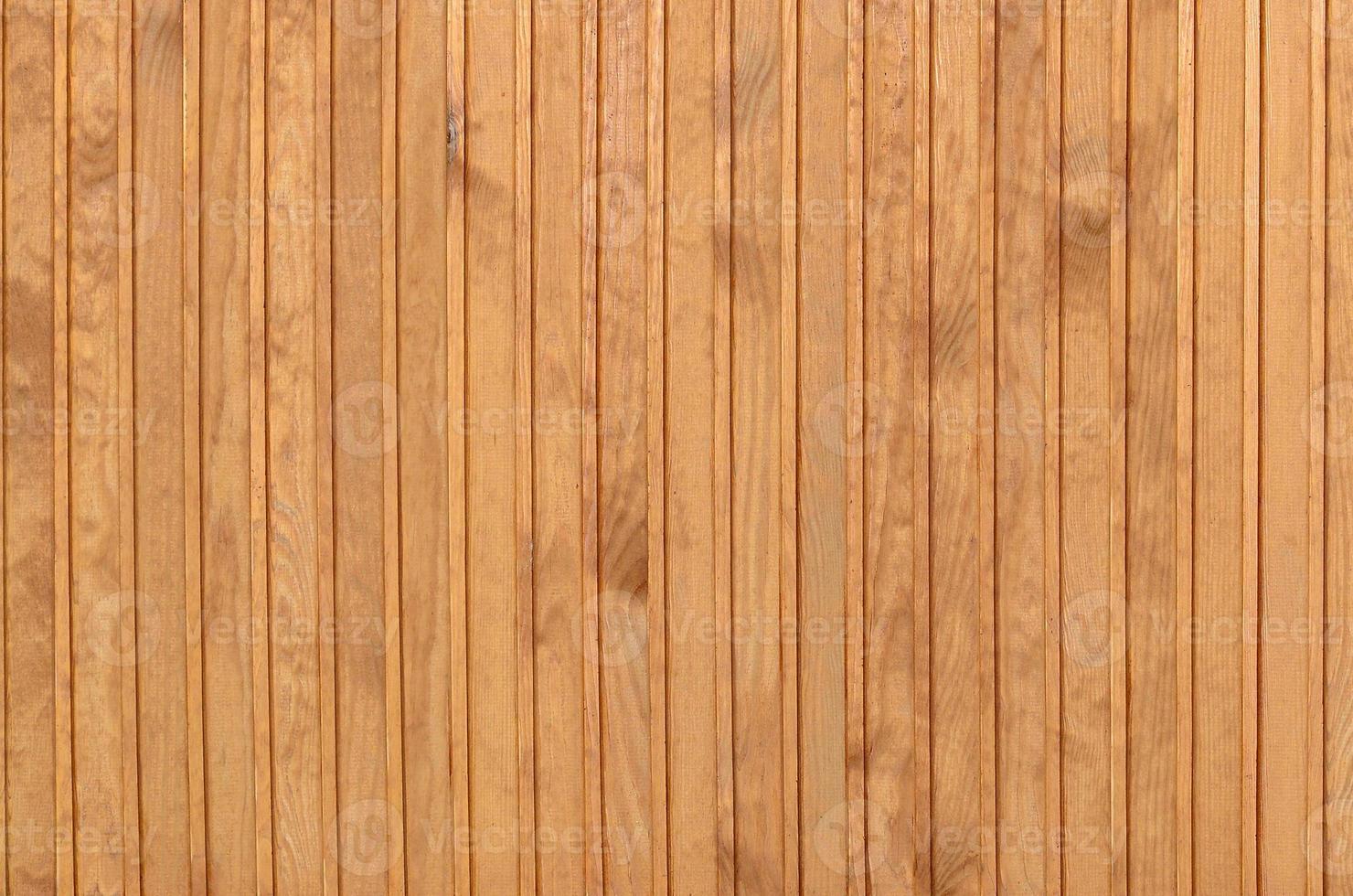 gros plan de panneaux de clôture en bois marron. de nombreuses planches de bois verticales photo