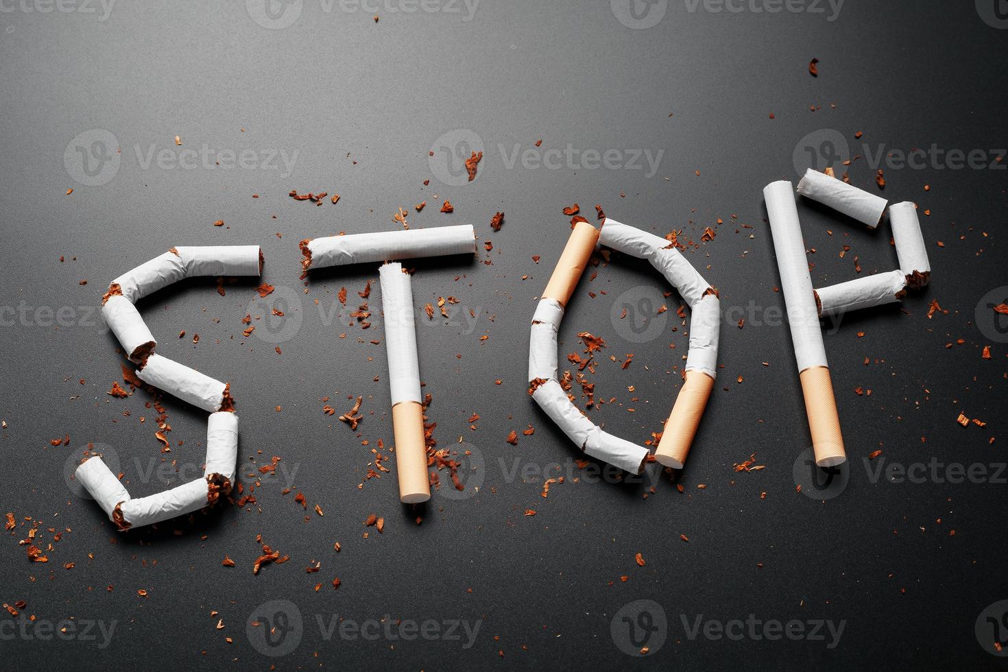 l'inscription stop de cigarettes sur fond noir. arrêter de fumer. le concept de fumer tue. inscription de motivation pour arrêter de fumer, habitude malsaine. photo