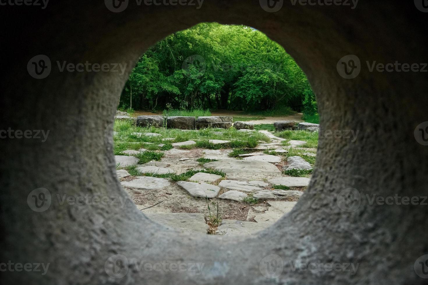 vue intérieure d'un dolmen en pierre à travers un trou dans une forêt de montagne dans la vallée de la rivière jean photo