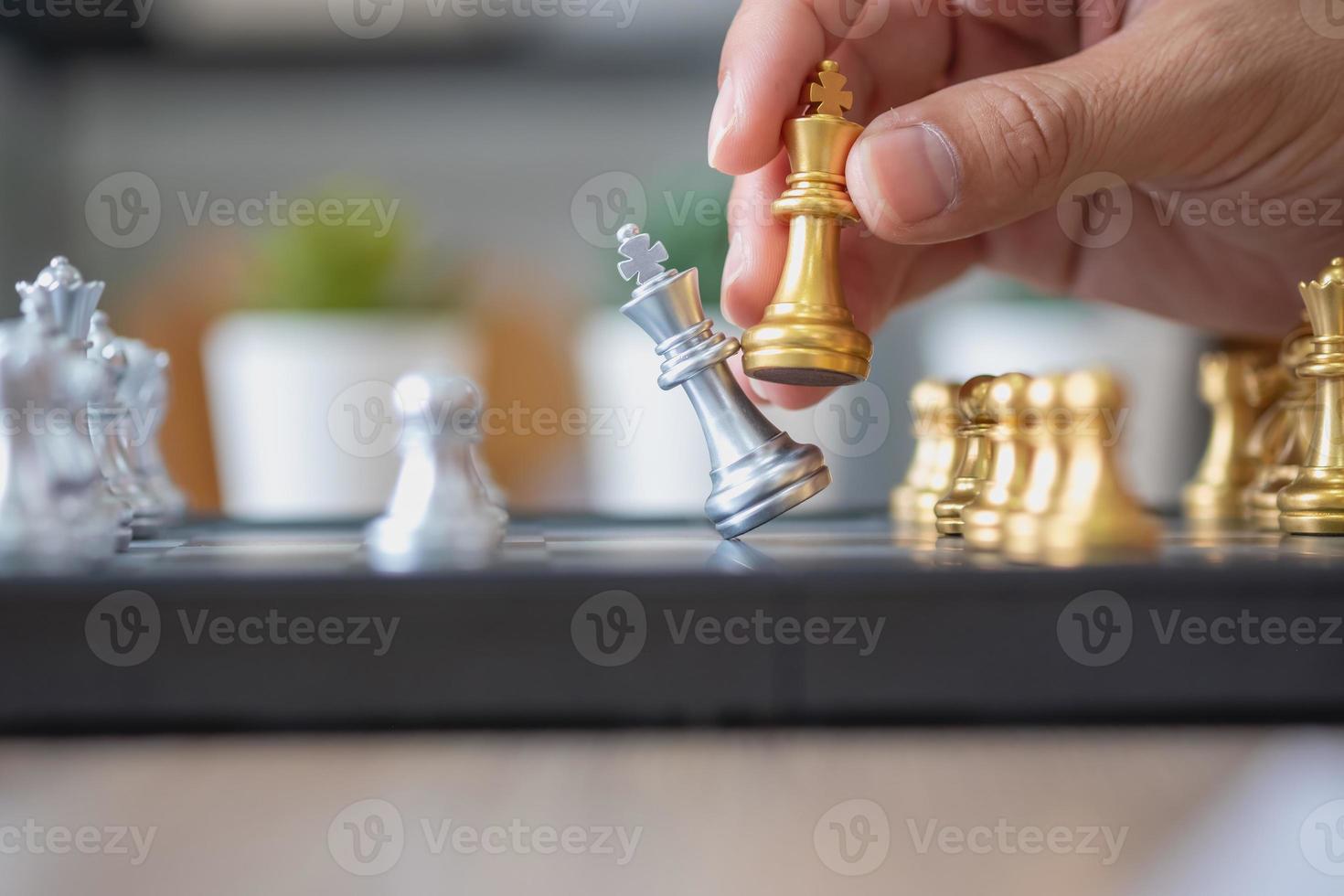 l'entreprise est un homme d'affaires, les mains bougent les échecs sur le plan de match pour gagner l'entreprise sur le marché. notion de leadership photo