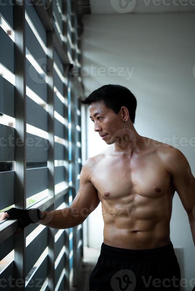 L'effet de l'exercice pour développer les muscles de la poitrine donne au jeune homme un corps intelligent et beau. photo