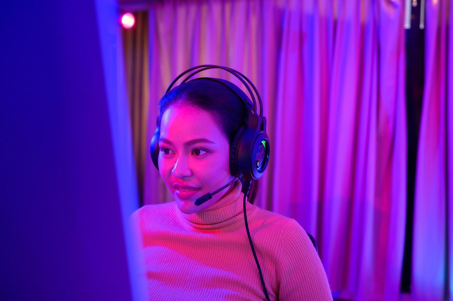 une jeune femme active et sérieuse qui joue sur son puissant ordinateur personnel, jouant à des jeux vidéo en ligne à la première personne. photo