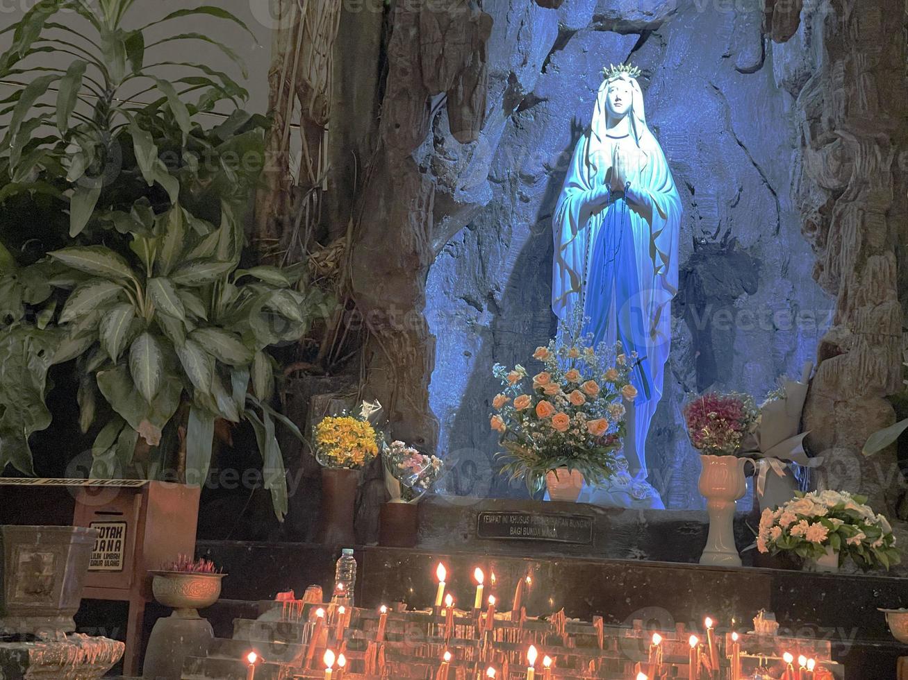 la grotte de la vierge marie, statue de la vierge marie dans une grotte rocheuse chapelle église catholique avec végétation tropicale photo