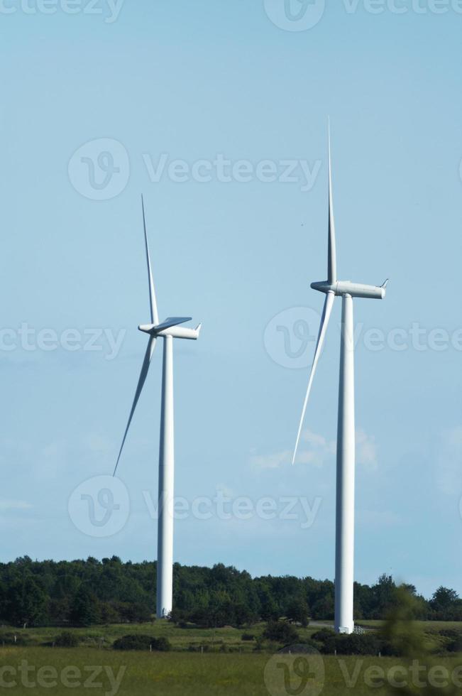 les moulins à vent se tiennent contre un ciel bleu nuageux photo