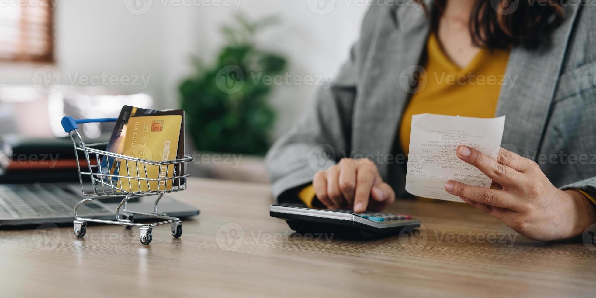 femme à l'aide d'une calculatrice tenant des factures papier calculant les dépenses de planification concept de paiements d'argent, mains féminines comptant les données TVA taxes coûtant faire de la paperasse à la maison photo