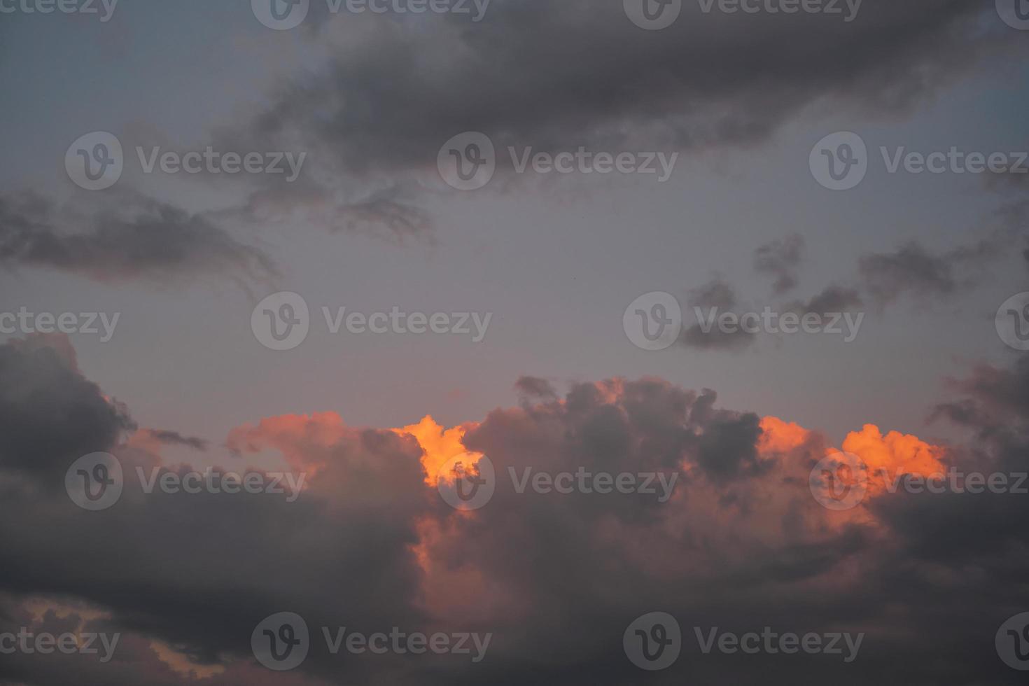 nuages dramatiques éclairés par le soleil sur un ciel coucher de soleil spectaculaire. mise au point sélective sur les nuages, l'arrière-plan ou l'idée de nouvelles météorologiques. photo