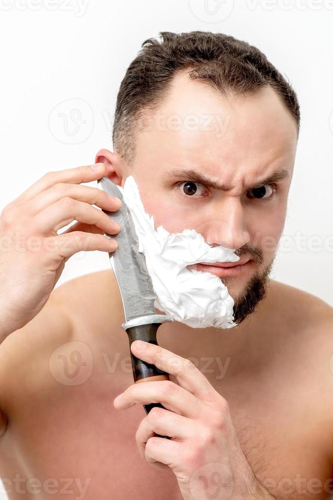 homme se rasant la barbe avec un couteau photo
