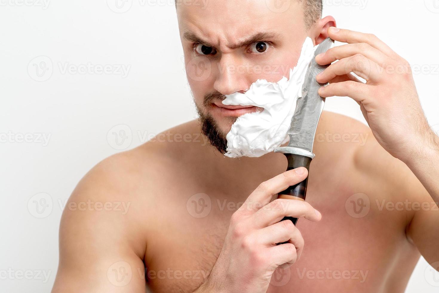 homme se rasant la barbe avec un couteau photo