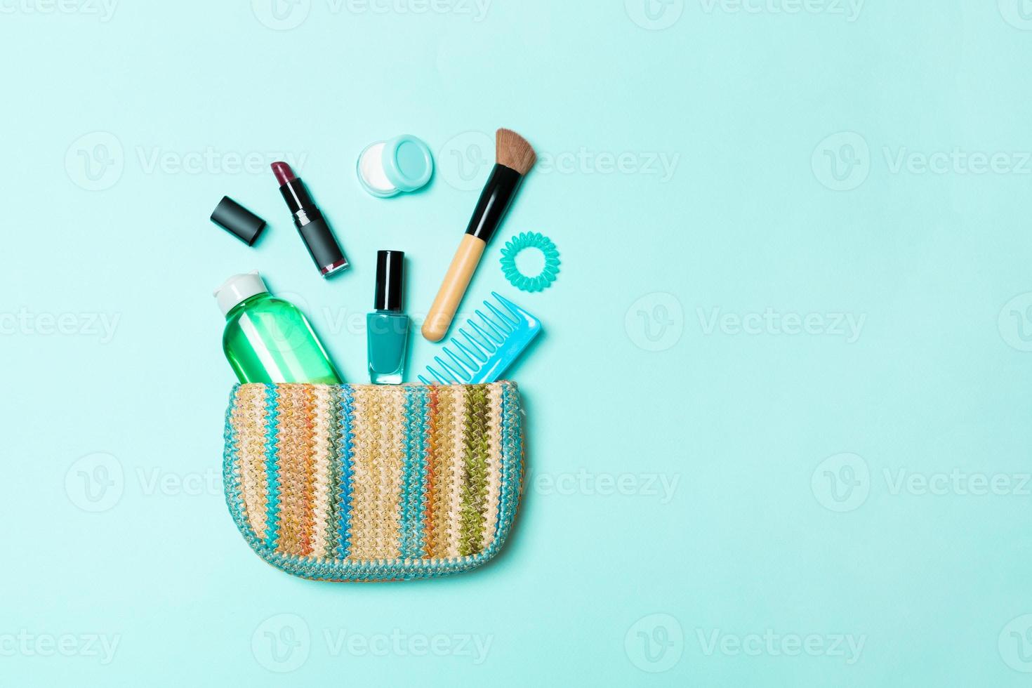produits de maquillage débordant de sac de cosmétiques sur fond bleu pastel avec un espace vide pour votre conception photo