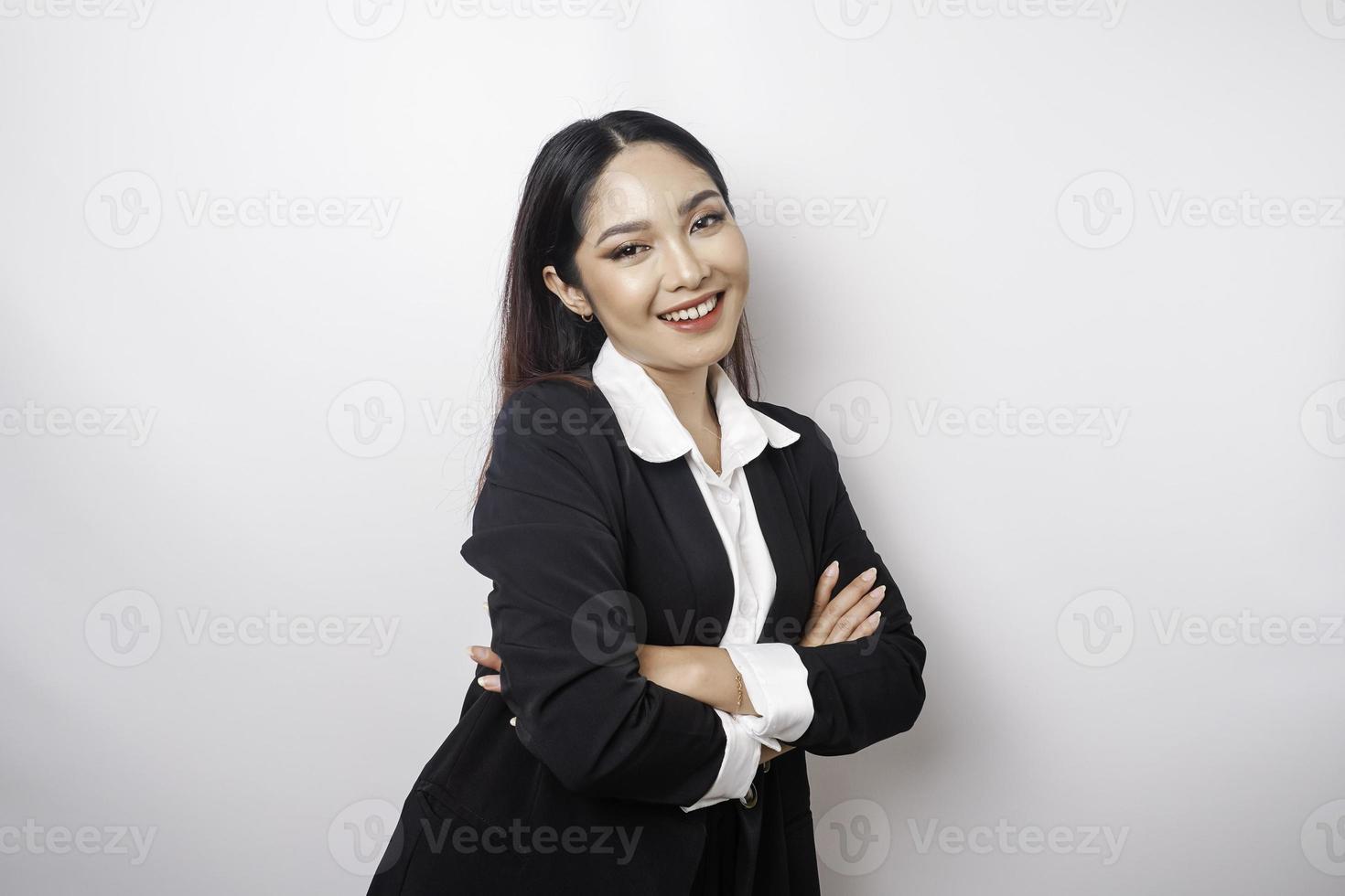 portrait d'une patronne souriante et confiante portant un costume noir debout avec les bras croisés et regardant la caméra isolée sur fond blanc photo
