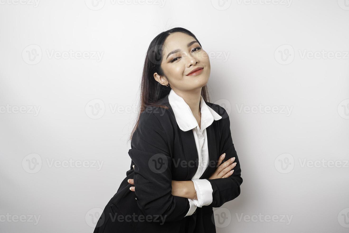 portrait d'une patronne souriante et confiante portant un costume noir debout avec les bras croisés et regardant la caméra isolée sur fond blanc photo