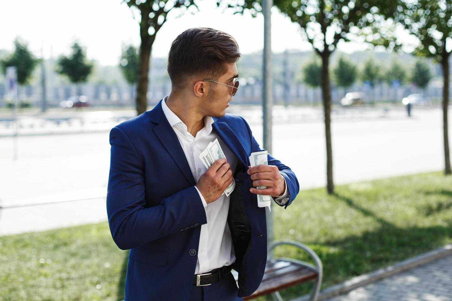 homme en costume met de l'argent dans sa poche intérieure photo