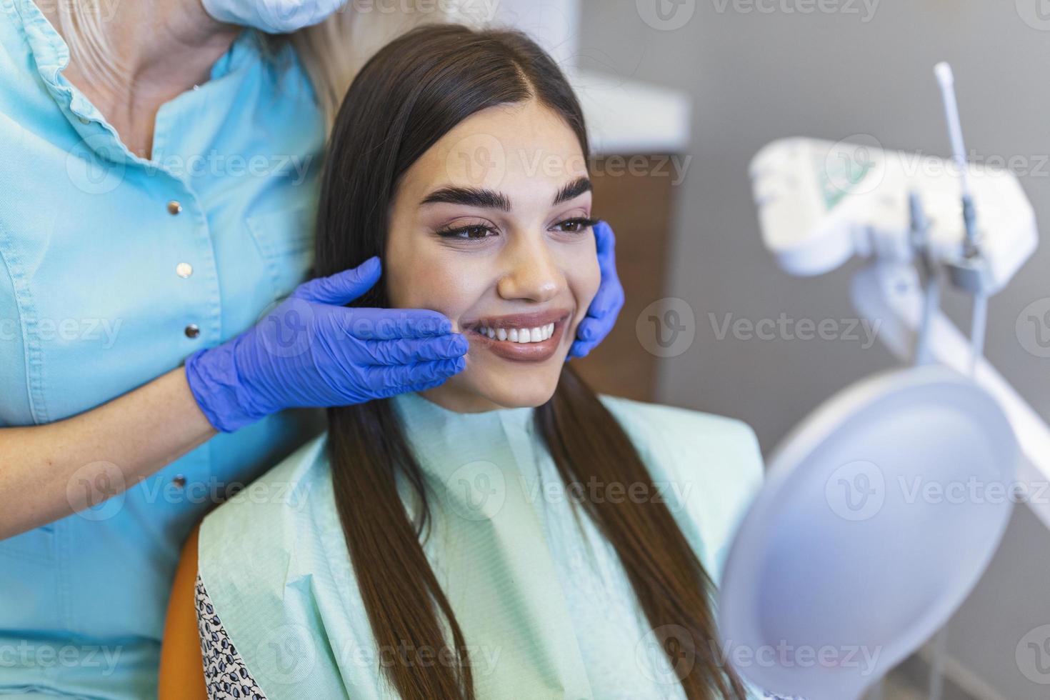 la femme se regarde dans le miroir dans la chaise du dentiste. a vu l'hygiène bucco-dentaire. femme chez le dentiste. femme dans le fauteuil dentaire traitement dentaire pendant la chirurgie. photo