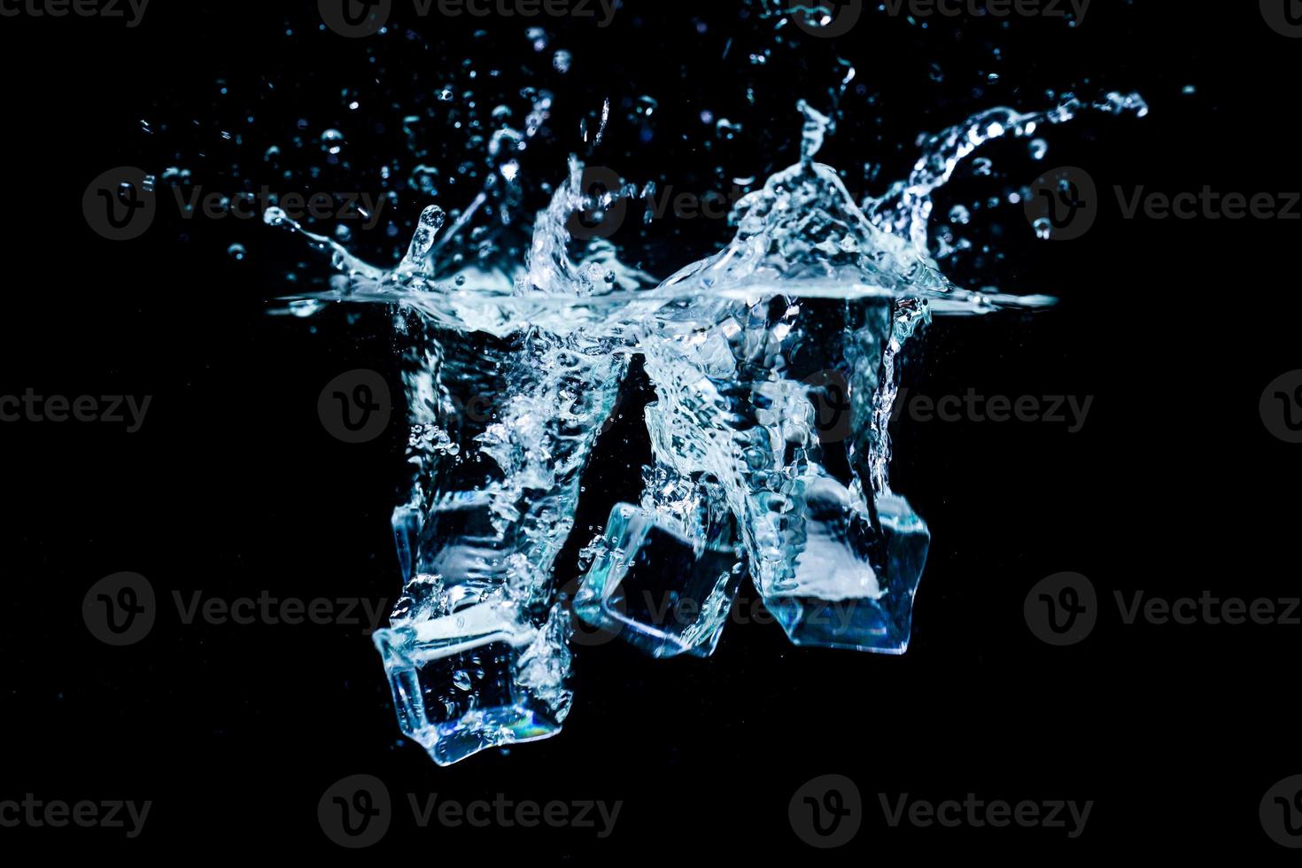 glaçons dans l'eau avec des bulles sur fond noir photo