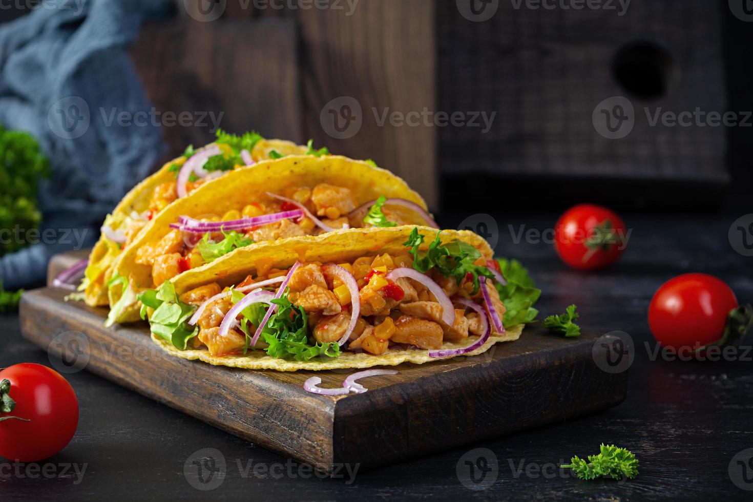 tacos mexicains avec tortilla de maïs. tortilla avec viande de poulet, maïs, laitue et oignon photo