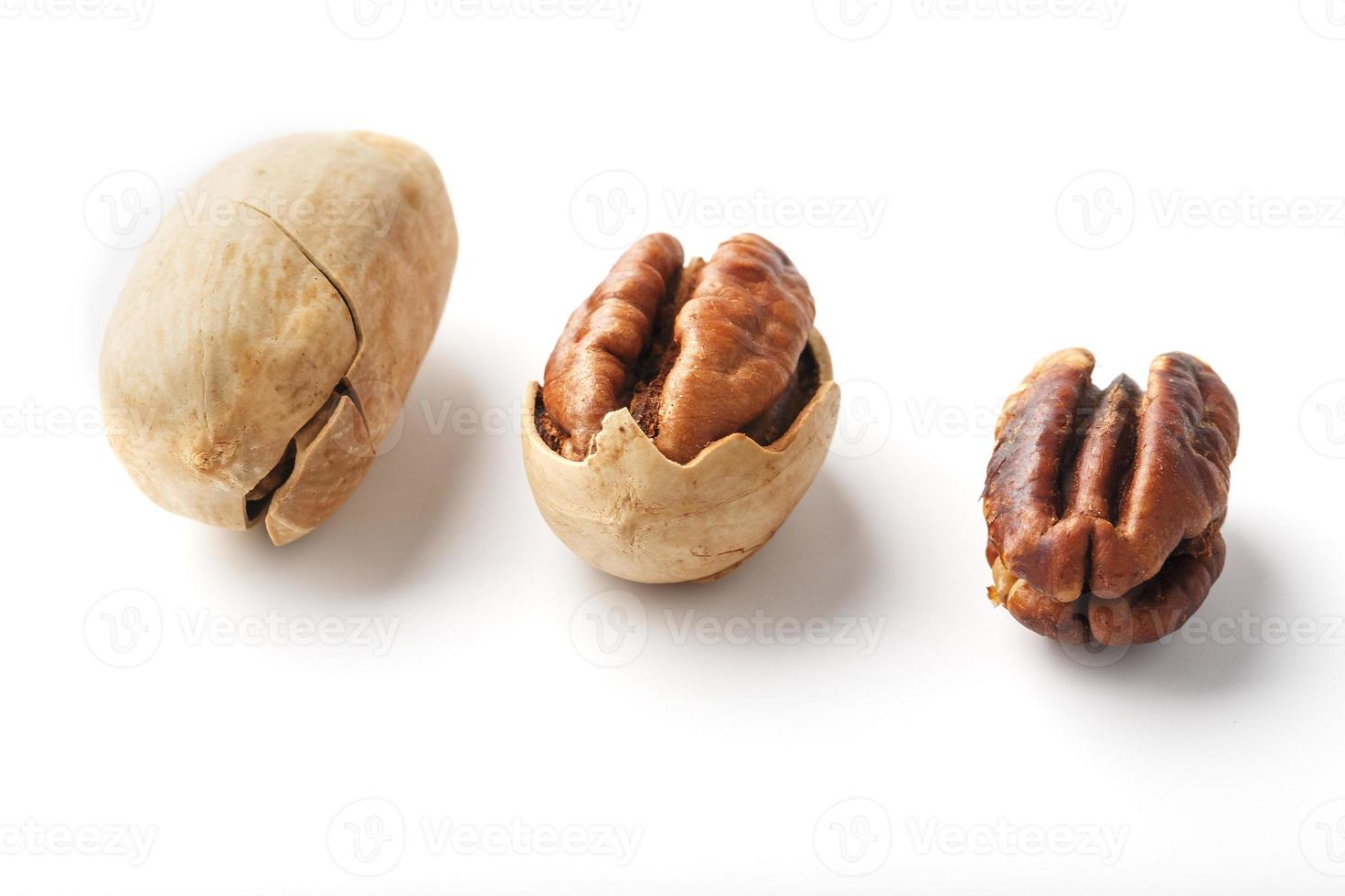 ensemble de trois noix de pécan au centre dans une coquille, pelées et sans coquille isolées sur fond blanc d'affilée. photo