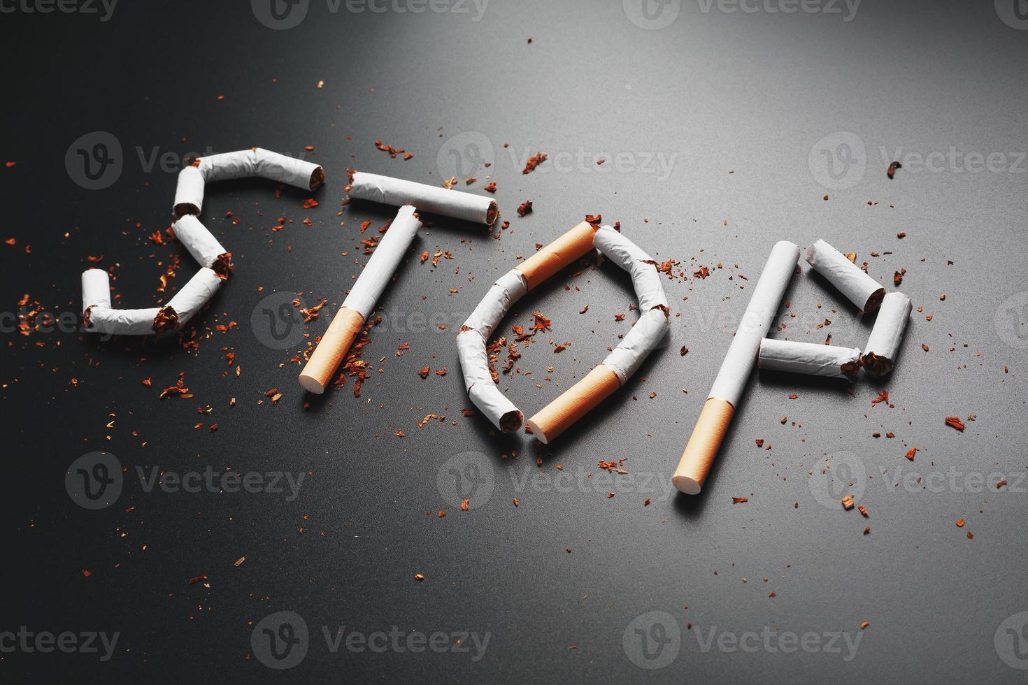 l'inscription stop de cigarettes sur fond noir. arrêter de fumer. le concept de fumer tue. inscription de motivation pour arrêter de fumer, habitude malsaine. photo