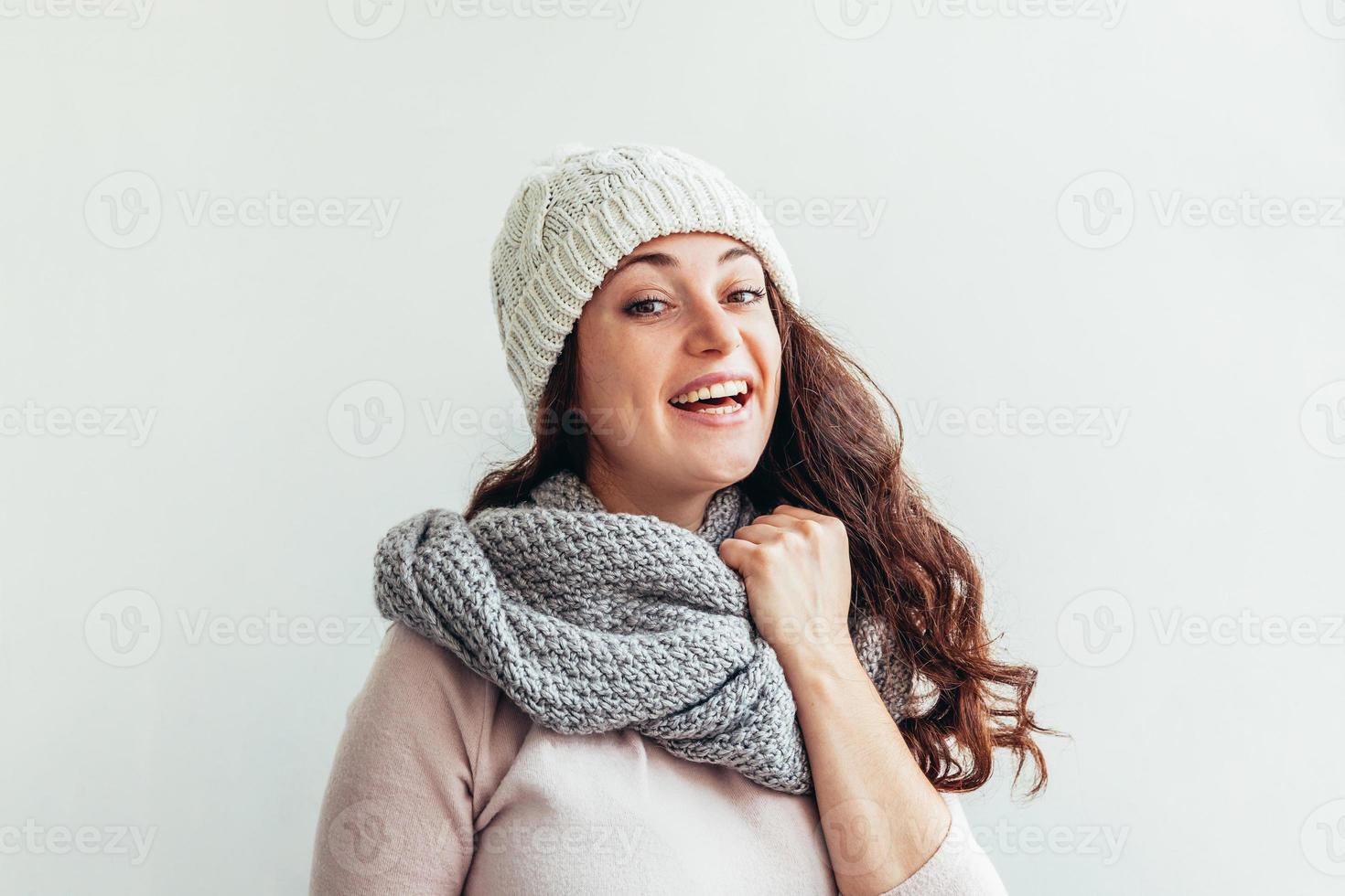 Laughing girl portant des vêtements chauds bonnet et écharpe isolé sur fond blanc photo