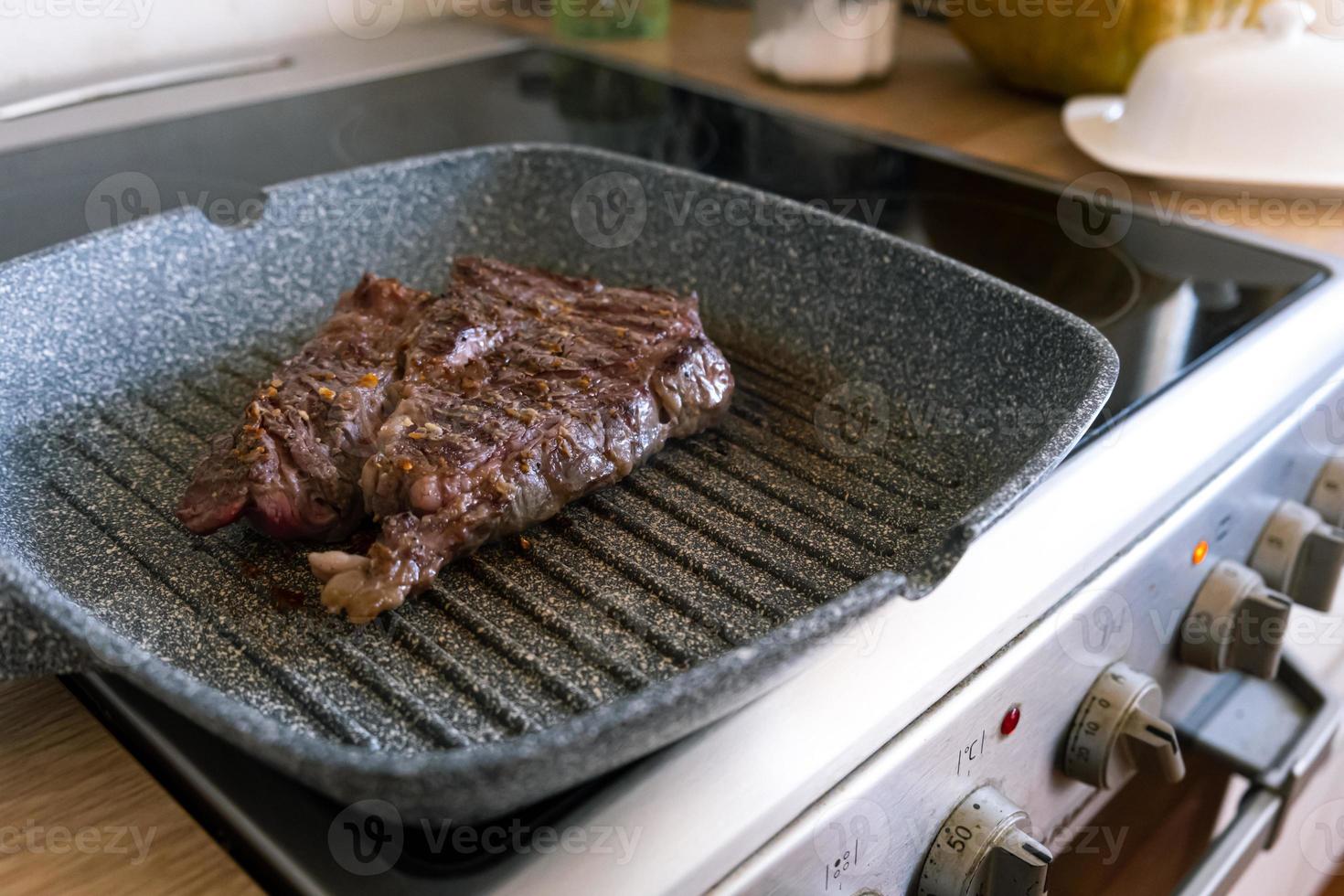 steak de viande de boeuf juteux cuit sur une plaque chauffante dans une cuisine professionnelle. premier steak friture au gril. cuisine délicieuse et moderne. photo