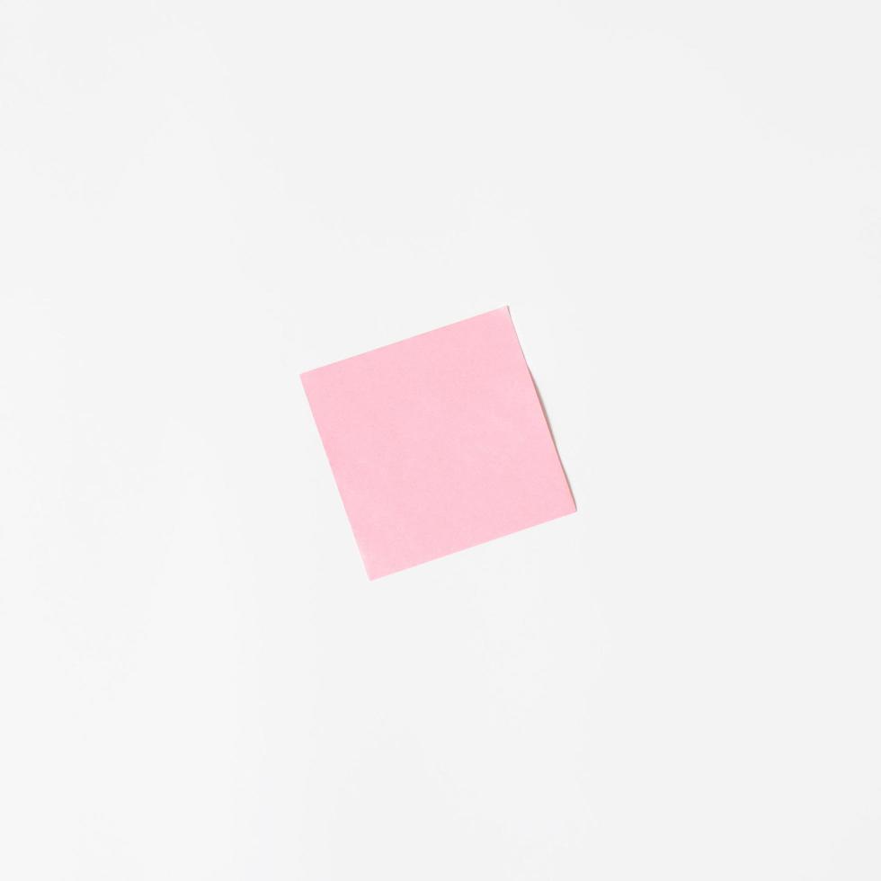 autocollant rose sur un mur blanc, maquette. feuille collante vierge, minimalisme photo