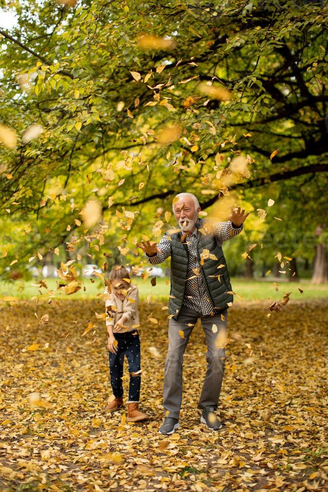 grand-père passe du temps avec sa petite-fille dans le parc le jour de l'automne photo