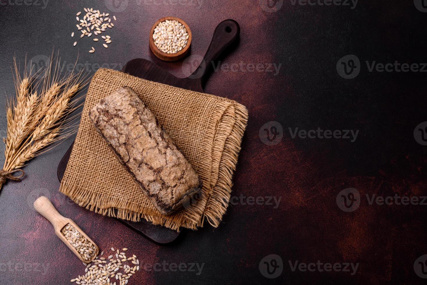 une miche de pain brun avec des grains de céréales sur une planche à découper en bois photo