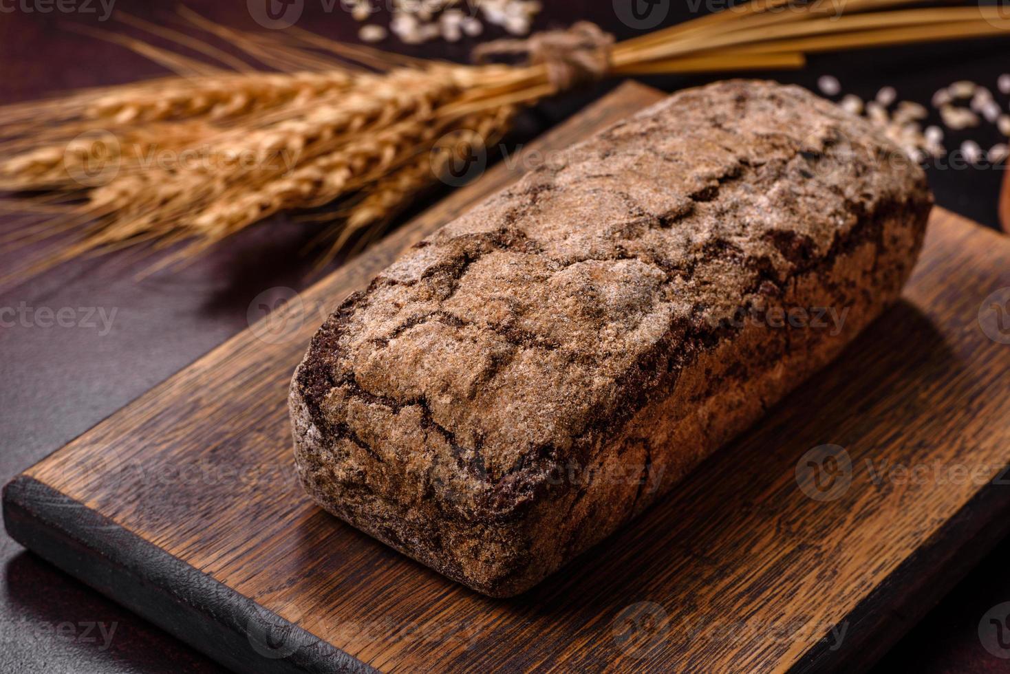 une miche de pain brun avec des grains de céréales sur une planche à découper en bois photo