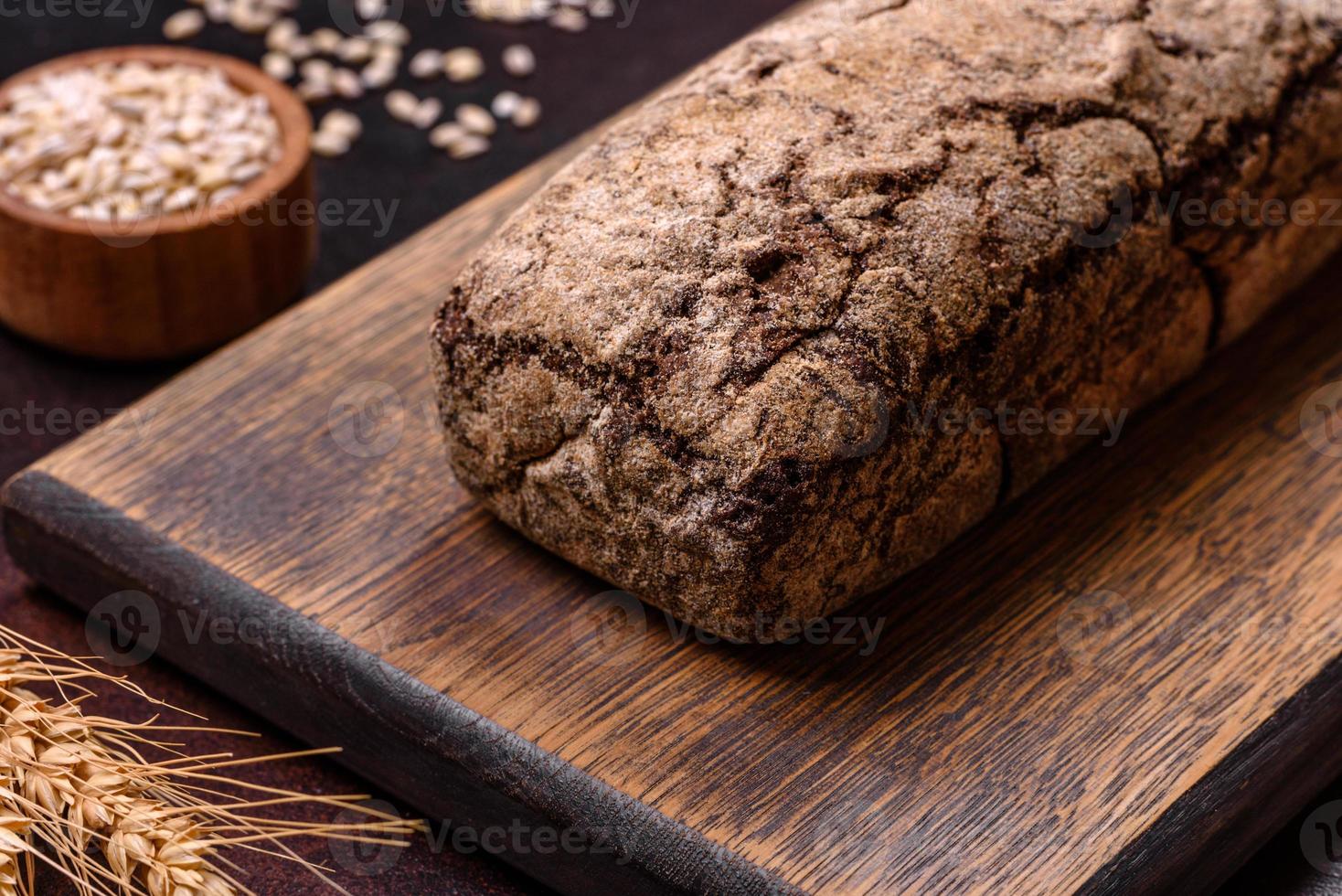 une miche de pain brun avec des grains de céréales sur une planche à découper en bois photo