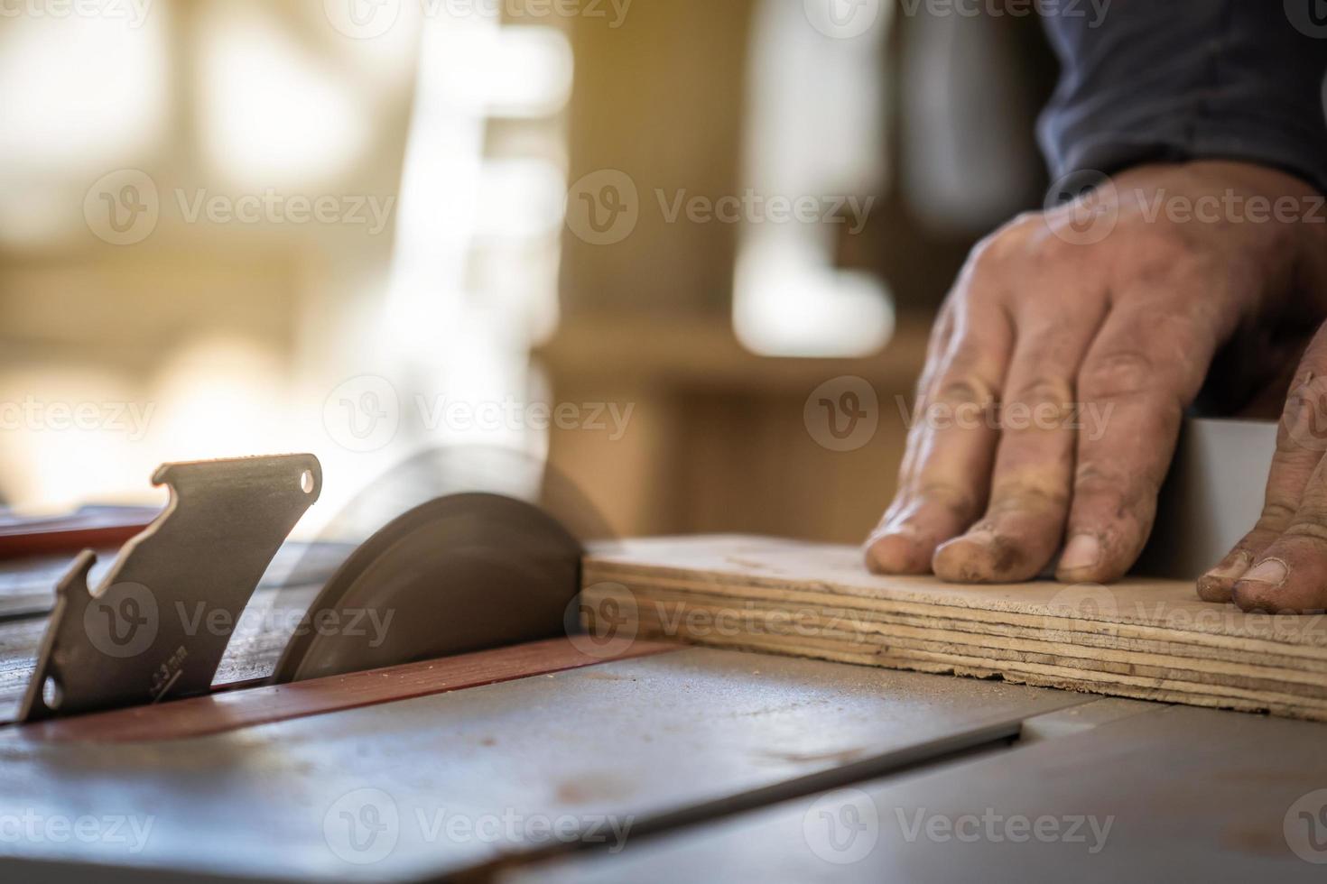 charpentier coupant une planche de bois dans son atelier. photo
