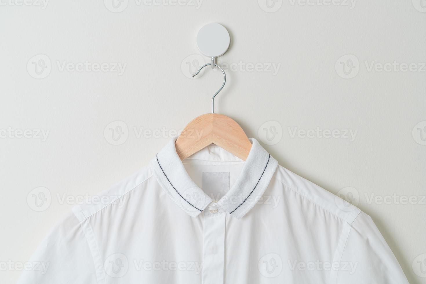 chemise suspendue avec cintre en bois au mur photo